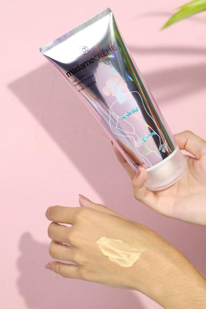 mãos segurando o hidratante iluminador glow lotion da madamecrème mostrando a embalagem e textura do produto